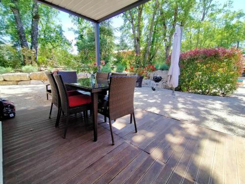 a table and chairs on a deck with an umbrella at Modern Villa with Pool in Montauroux France in Montauroux
