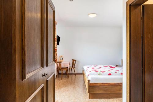 a bedroom with a bed and a table with a chair at Pension Heidelberg in Hopfgarten im Brixental