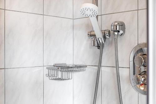 a shower with a shower head in a bathroom at Pension Heidelberg in Hopfgarten im Brixental