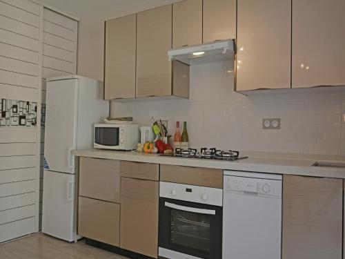 a kitchen with a white refrigerator and a microwave at Modern Villa with Pool in Montauroux France in Montauroux