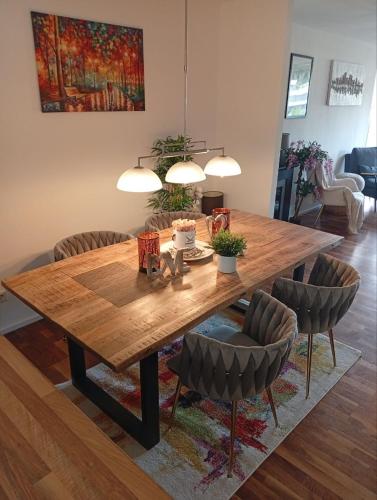 a wooden table with chairs and a dining room at Luxus Business Apt mit Badewanne Balkon und Tiefgaragenstellplatz in Kerpen