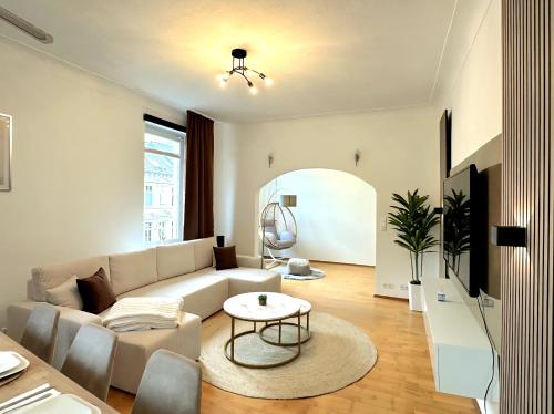 a living room with a couch and a table at Casa Mia - Helios Klinik - HBF - Zentrum - Parken - Messe 20 Min in Krefeld