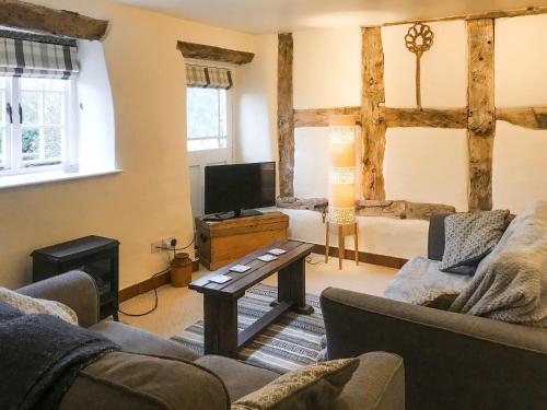 a living room with a couch and a tv at Jasmine Cottage - Uk4176 in Mayfield