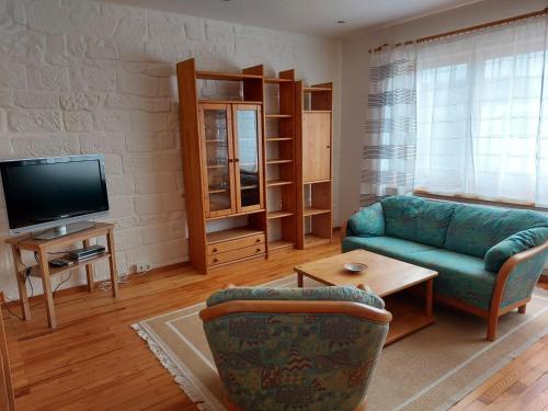 a living room with a couch and a tv at Ferienwohnung Hildegard in Ormesheim