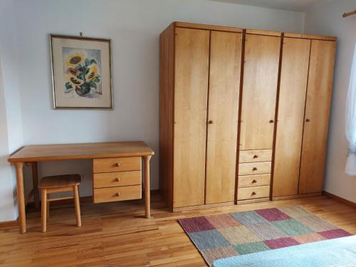 a bedroom with a desk and a wooden cabinet at Ferienwohnung Hildegard in Ormesheim