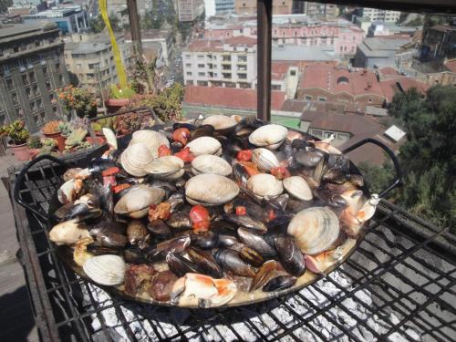 a bunch of clams and mussels on a grill at The Travelling Chile in Valparaíso