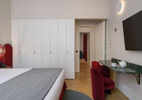 a bedroom with a bed and a table and chairs at Montebelo Vista Alegre Lisboa Chiado Hotel in Lisbon