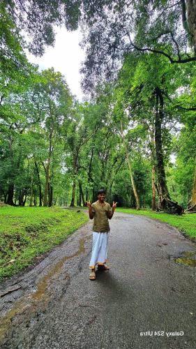 a woman walking down a road with her hands in the air at Forest Haven in Batheri