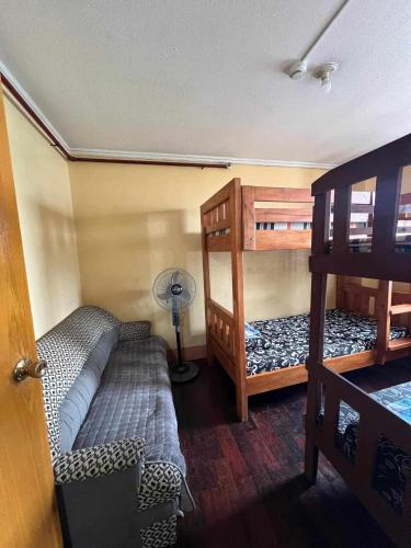 a bedroom with two bunk beds and a fan at Unit 302, 3rd Floor in Baguio
