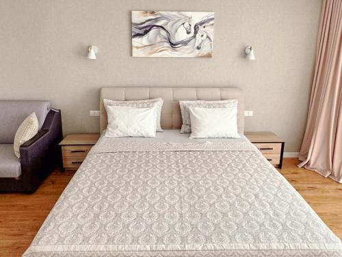 a bedroom with a large bed with two pillows at Stunning new design apartment next to park in Chişinău
