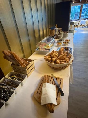 a long table with bread and other foods on it at Hôtel de Paris in Châtel-Guyon