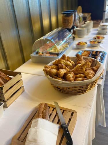 a buffet line with bread and a basket of pastries at Hôtel de Paris in Châtel-Guyon