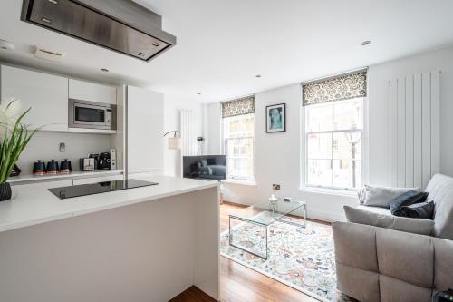 a white kitchen and living room with a couch at Central Stays at Liverpool Street in London