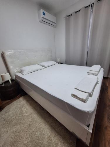 a bedroom with a large bed with white sheets at Villa Srna Apartments 