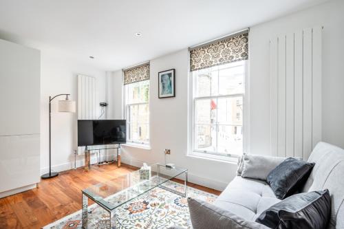 a living room with a couch and a glass table at Central Stays at Liverpool Street in London