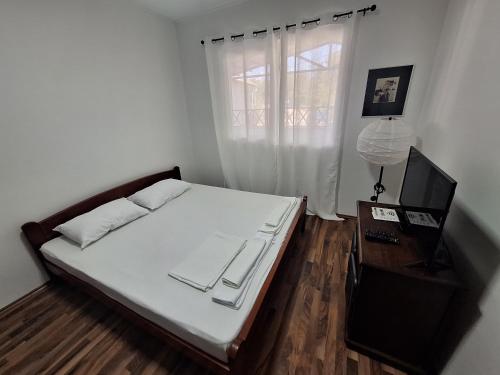 a small bedroom with a bed and a window at Villa Srna Apartments 