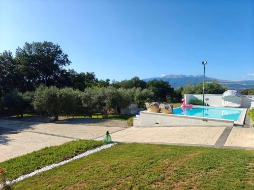 a backyard with a swimming pool and a grass field at Villa Le Terre in Cepagatti