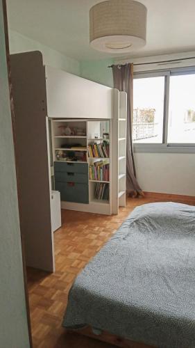 une chambre avec un lit et une étagère dans l'établissement Appartement familial 2 chambres, à Lyon