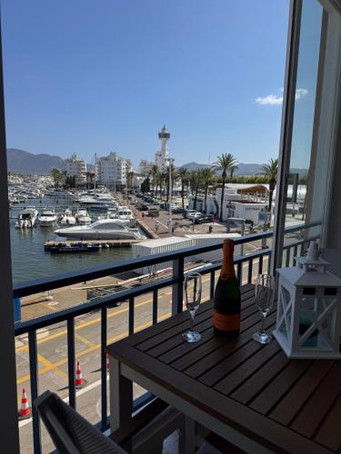 a balcony with a table with wine glasses and a harbor at Marina View II Empuriabrava - view port in Empuriabrava
