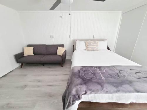 a bedroom with a large bed and a couch at Beachfront Condo with Ocean View in Hauula