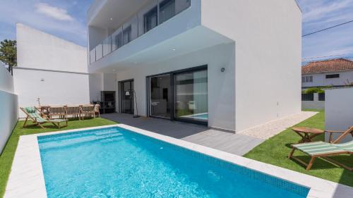 a villa with a swimming pool in the backyard at Villa Aroeira with Pool by LovelyStay in Aroeira