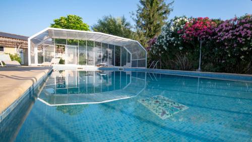 - une piscine avec une serre en verre au-dessus dans l'établissement L'Aparte - T3 Les Oliviers, à Pignans