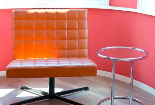 an orange chair and a stool in a room at Hotel Beethoven Wien in Vienna