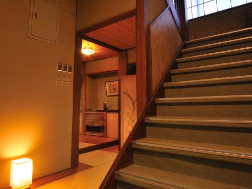 a hallway with stairs in a building with a light at Hanakanzashi in Nihommatsu