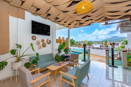 a patio with furniture and a view of a pool at Kata Hill Sea View Hotel in Kata Beach