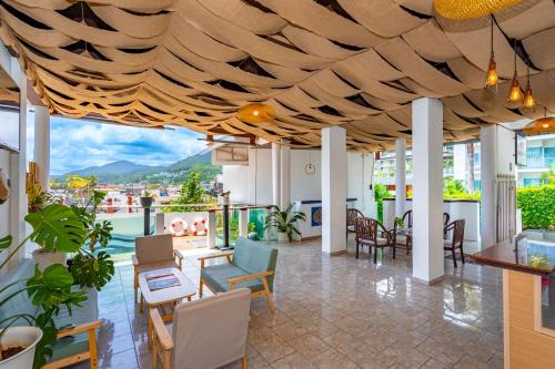 a lobby with tables and chairs and a view at Kata Hill Sea View Hotel in Kata Beach
