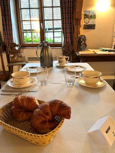 een tafel met een mand met croissants erop bij Chambres d'hôtes Ruhlmann in Dambach-la-Ville