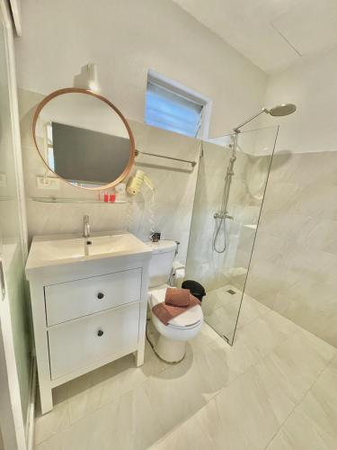 a bathroom with a toilet and a sink and a mirror at Green Gallery Beach Boutique Hotel in Hua Hin