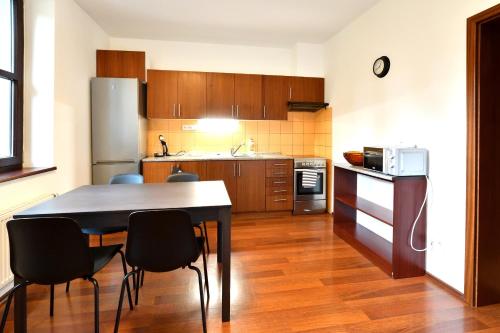 a kitchen with a table and chairs and a refrigerator at Apartmán na Sportovním areálu in Krásná Lípa
