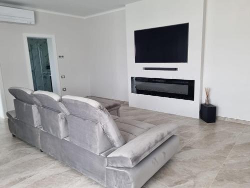 a living room with a couch and a flat screen tv at Vila Alma in Ilganii de Jos