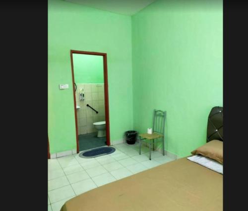 a bedroom with a bed and a bathroom with a mirror at Comfy Transit in Tawau