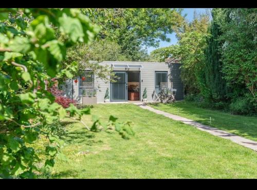 a small house in a yard with a grass yard at The Lodge Heaton Moor in Manchester