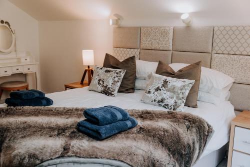 ein Schlafzimmer mit einem Bett mit blauen Handtüchern darauf in der Unterkunft Charming Dual - Cottage A Private Modern Retreat in Llanarthney