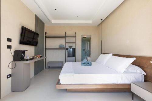 a bedroom with a white bed and a television at Bed & Mare by Perle di Puglia in Baia Di Gallipoli