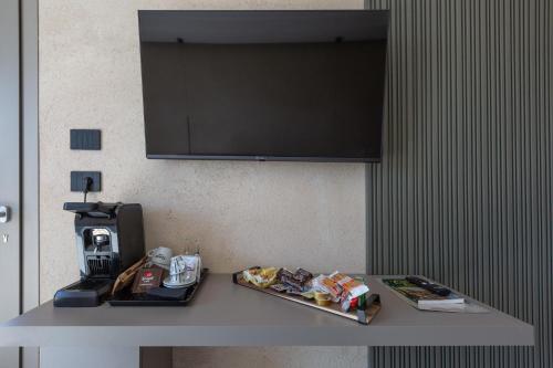 a table with food and a television on a wall at Bed & Mare by Perle di Puglia in Baia Di Gallipoli