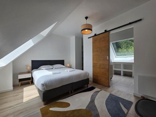 a bedroom with a bed and a large window at Les Quatre Baies in Guichen