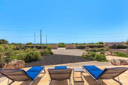 a group of lounge chairs sitting on a patio at Bed & Mare by Perle di Puglia in Baia Di Gallipoli