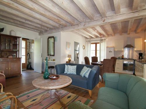 a living room with a blue couch and a table at Very nice cottage with studio on a domain with heated pool in Roussines