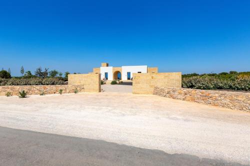 a building with stone walls and a blue sky at Bed & Mare by Perle di Puglia in Baia Di Gallipoli