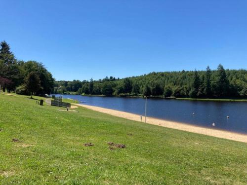 a park with a body of water and a grass field at Very nice cottage with studio on a domain with heated pool in Roussines