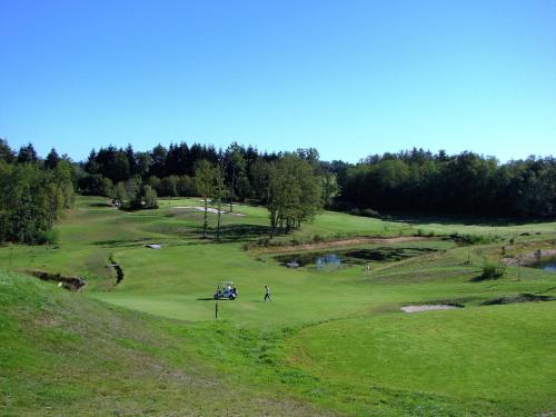 a golfer is playing on a golf course at Very nice cottage with studio on a domain with heated pool in Roussines