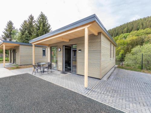 a small house with a patio and a table at Nice bungalow in Hallschlag near the lakebeach in Hallschlag