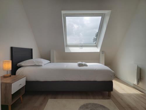 a bedroom with a bed and a window at Les Quatre Baies in Guichen