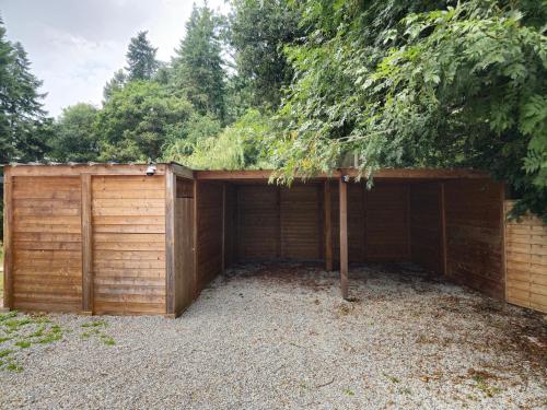 a wooden garage with a tree on top of it at Les Quatre Baies in Guichen