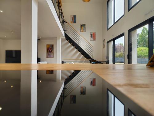 a staircase in a house with a reflection in the water at Les Quatre Baies in Guichen