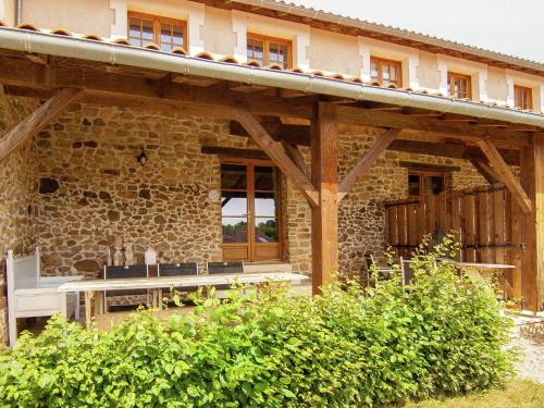 a stone house with a table and bench in front of it at Very nice cottage with studio on a domain with heated pool in Roussines